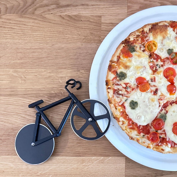 Pizzaschneider Fahrrad liegt auf Pizzateller