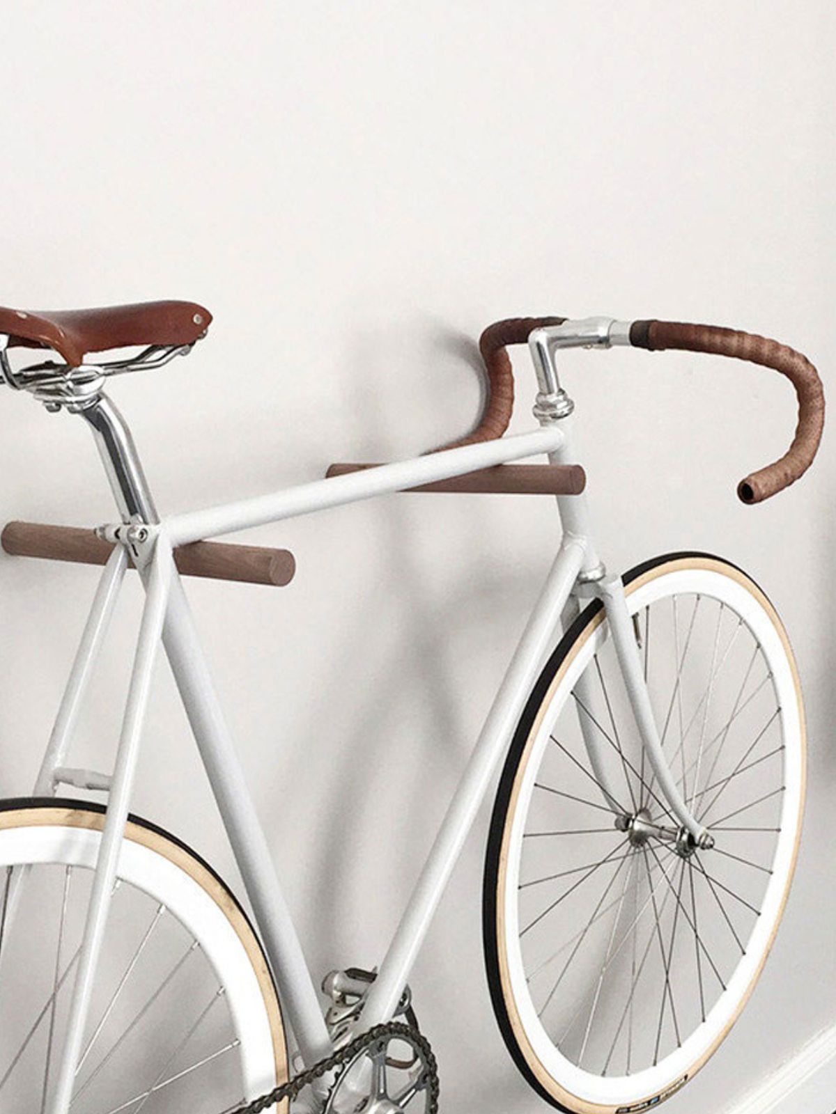 Fahrrad hängt auf zwei Sticks aus Holz die als Wandhalterung dienen