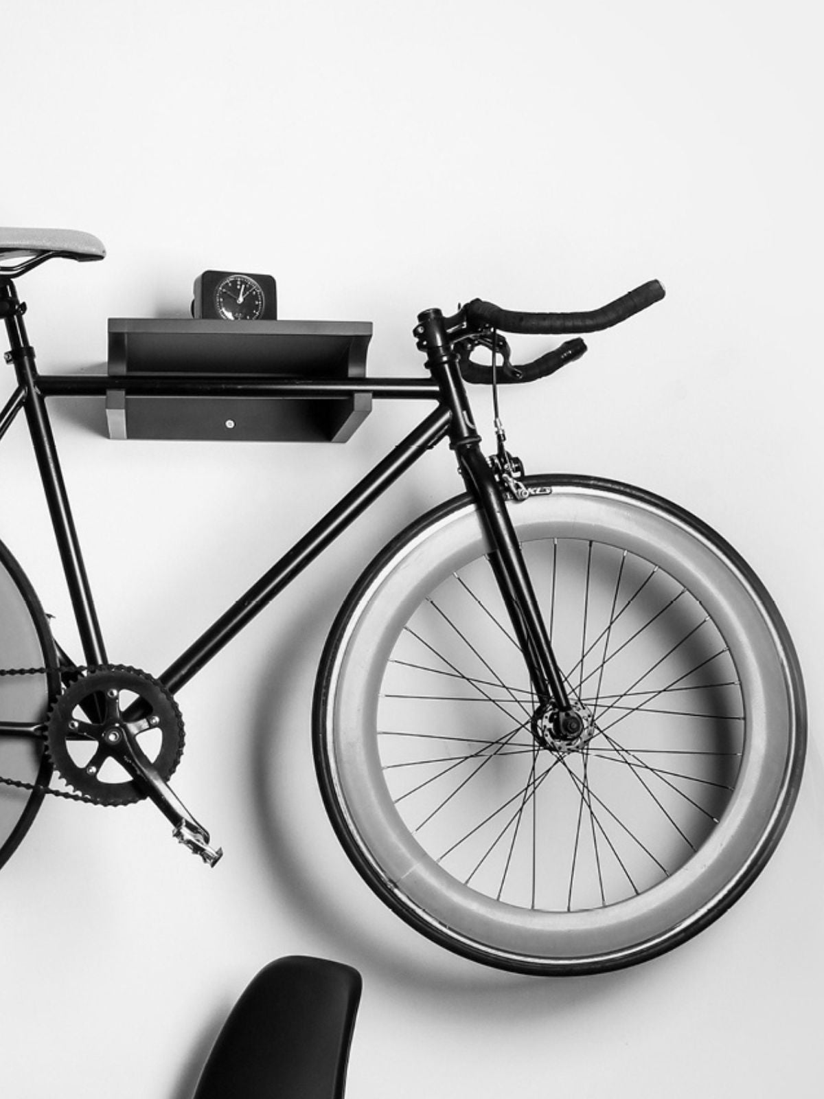 Schwarz-Weiß Bild von einem Fahrrad auf einer Wandhalterung
