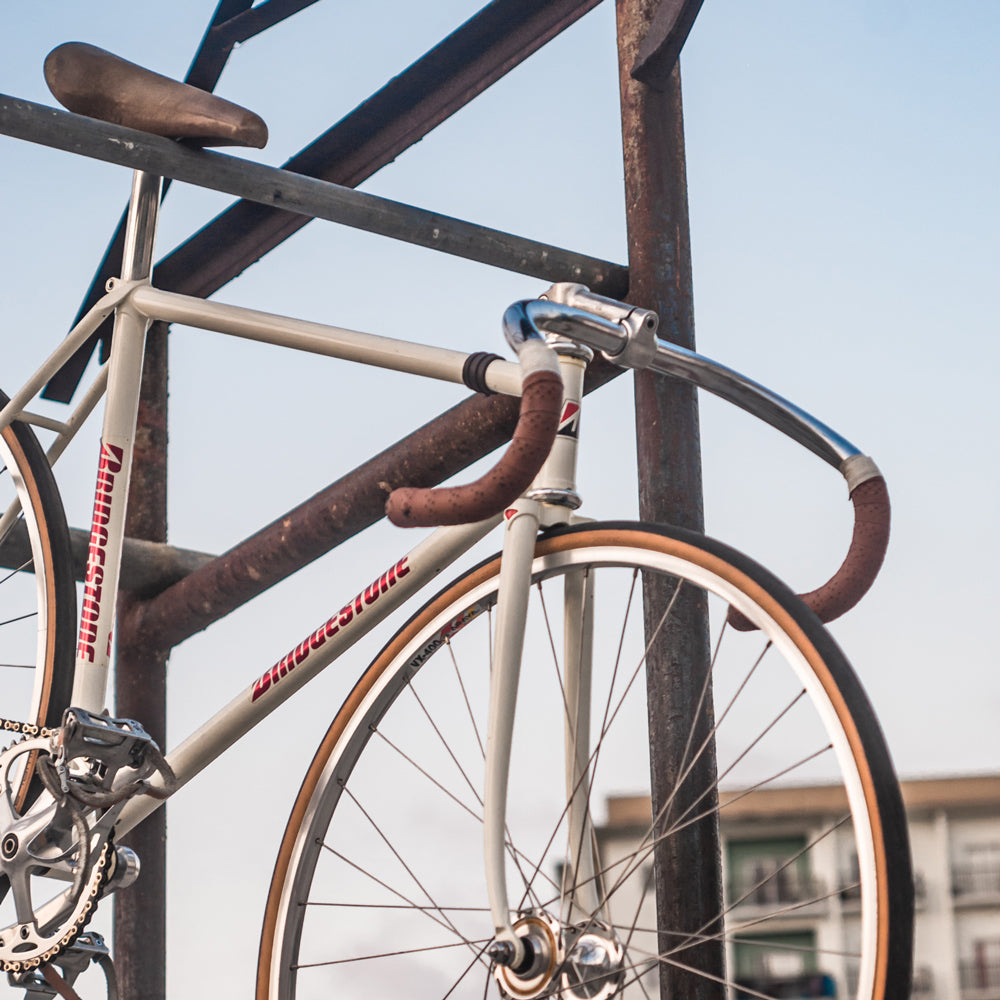Fahrrad mit braunem Lenkerband hängt an einem Gerüst